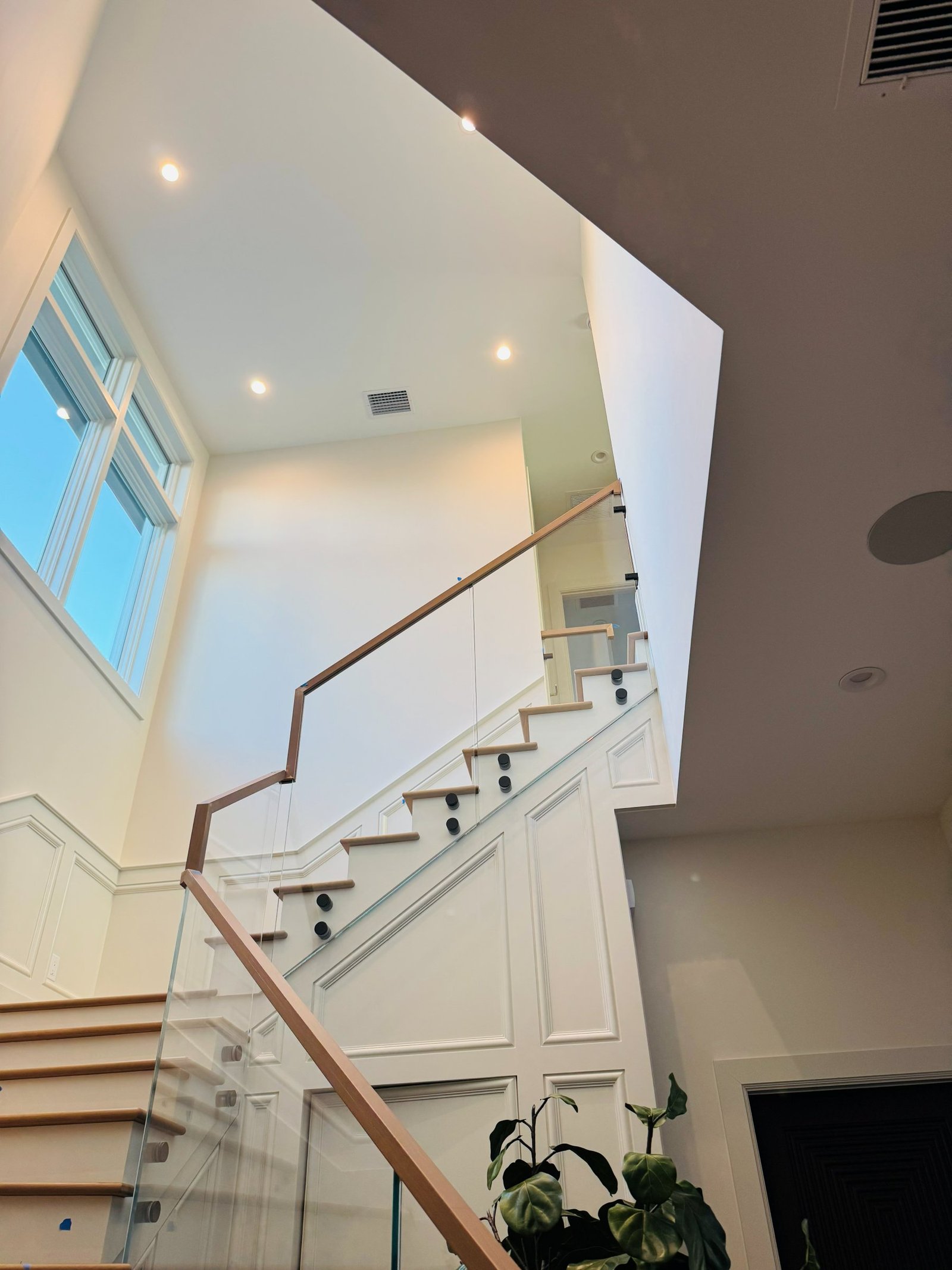 Glass railing detail viewed from below a staircase