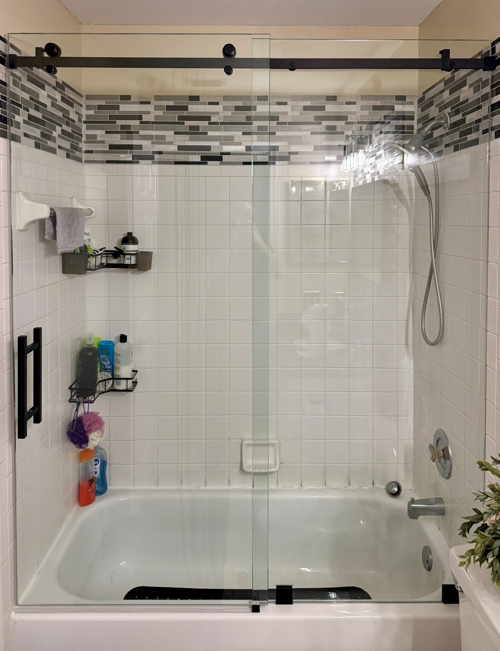 Glass shower and tub combination with mosaic tile accent
